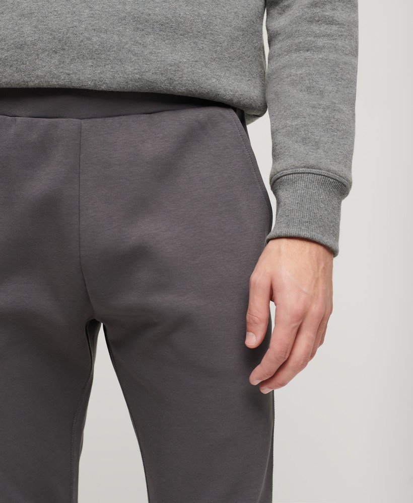 calça de moletom sport tech tapered na cor cinza escuro.