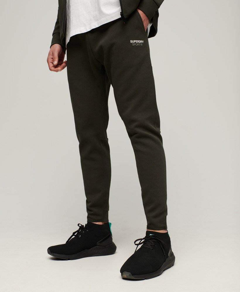 calças de corrida sport tech tapered na cor cáqui militar.