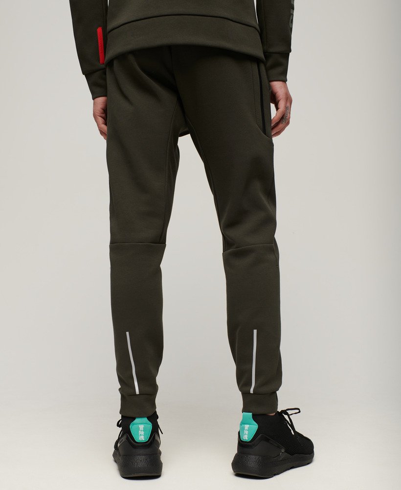 calças de corrida sport tech tapered na cor cáqui militar.