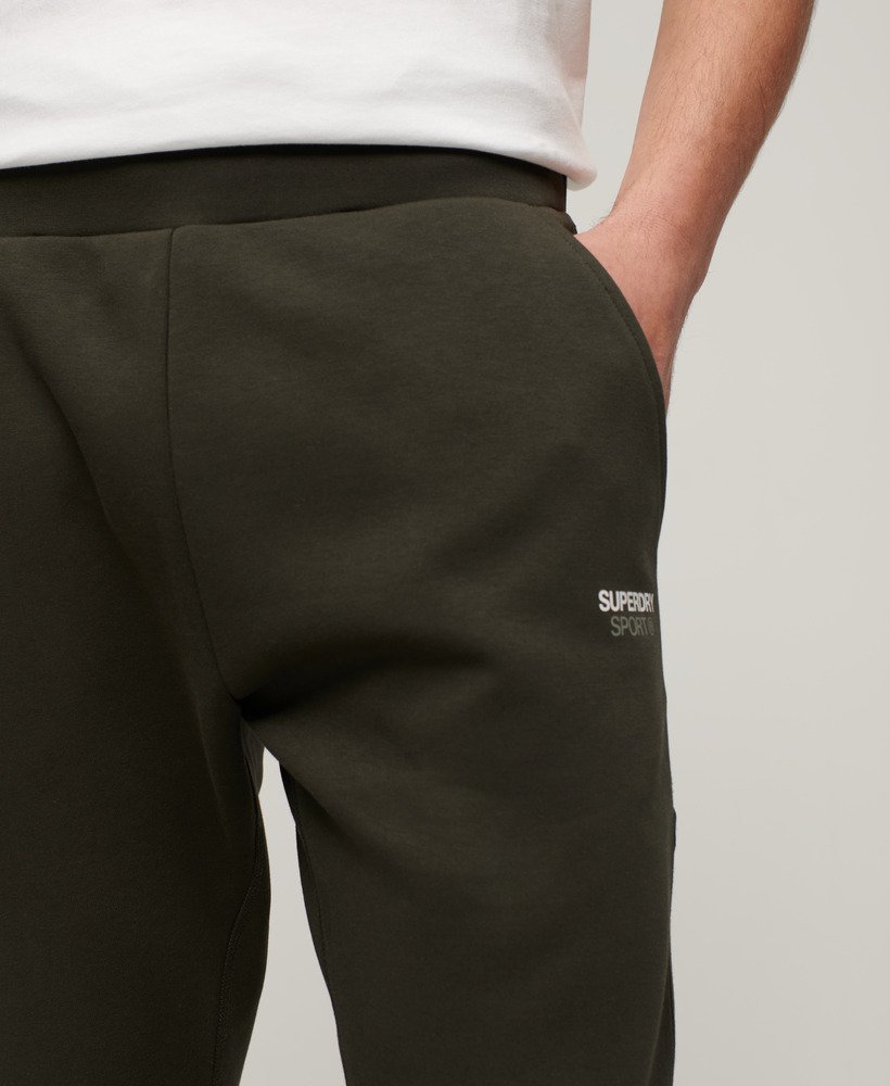 calças de corrida sport tech tapered na cor cáqui militar.