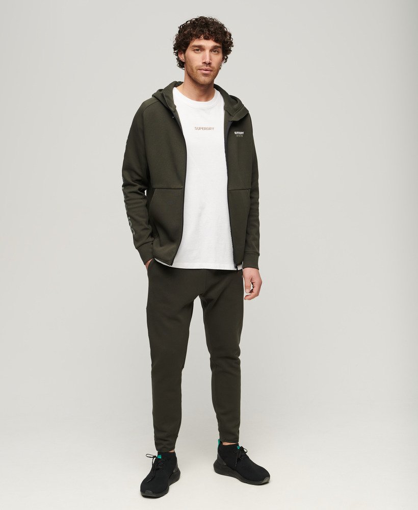 calças de corrida sport tech tapered na cor cáqui militar.