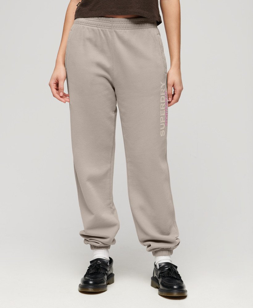 calça jogger estilo boyfriend esportiva em tecido texturizado bege escuro.