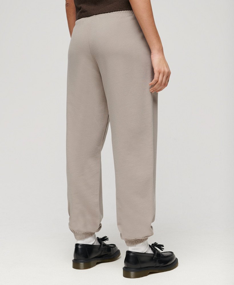 calça jogger estilo boyfriend esportiva em tecido texturizado bege escuro.