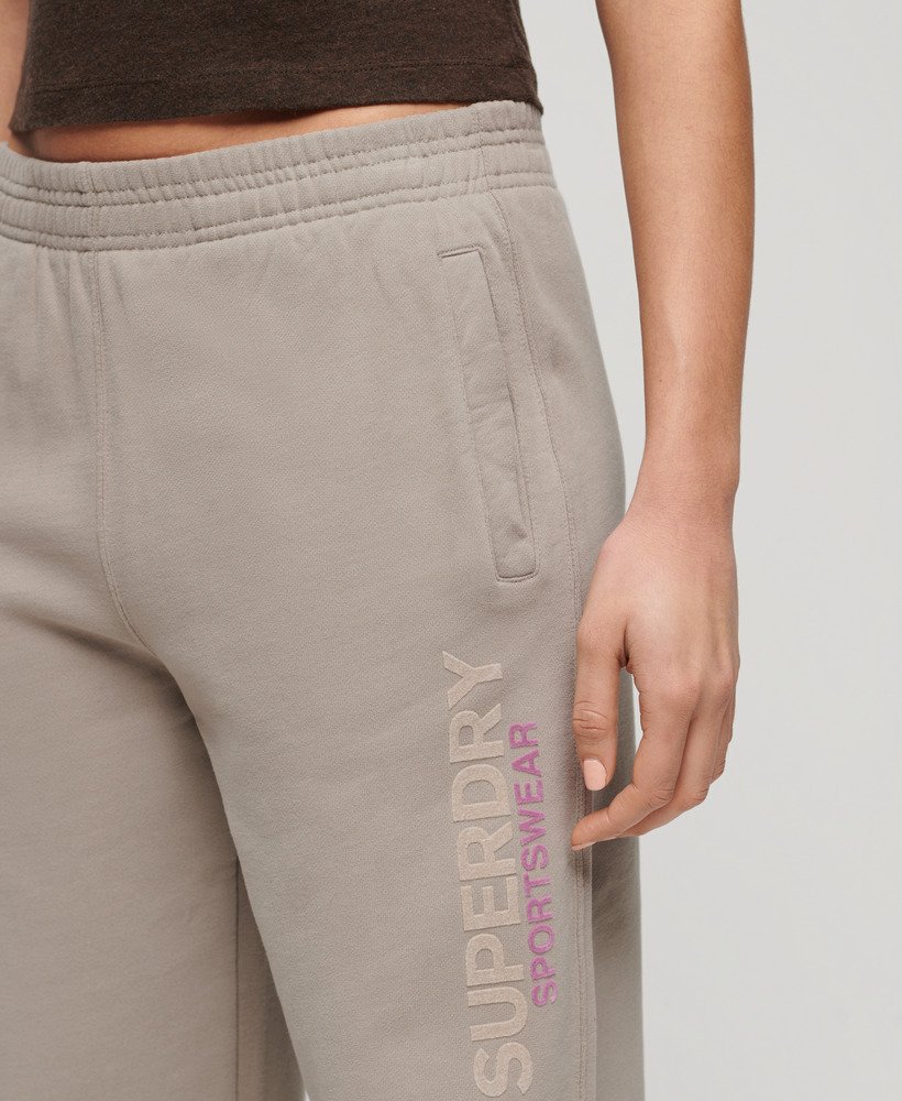 calça jogger estilo boyfriend esportiva em tecido texturizado bege escuro.