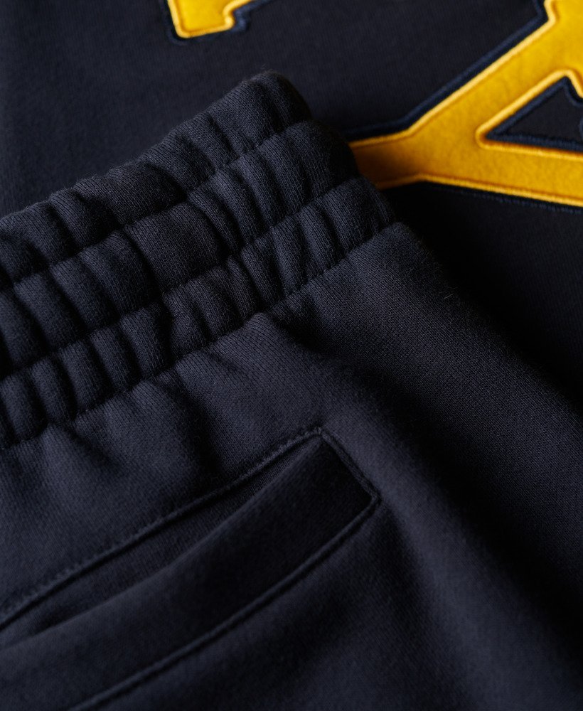 calça jogger masculina com logo universitário na cor azul-marinho eclipse.