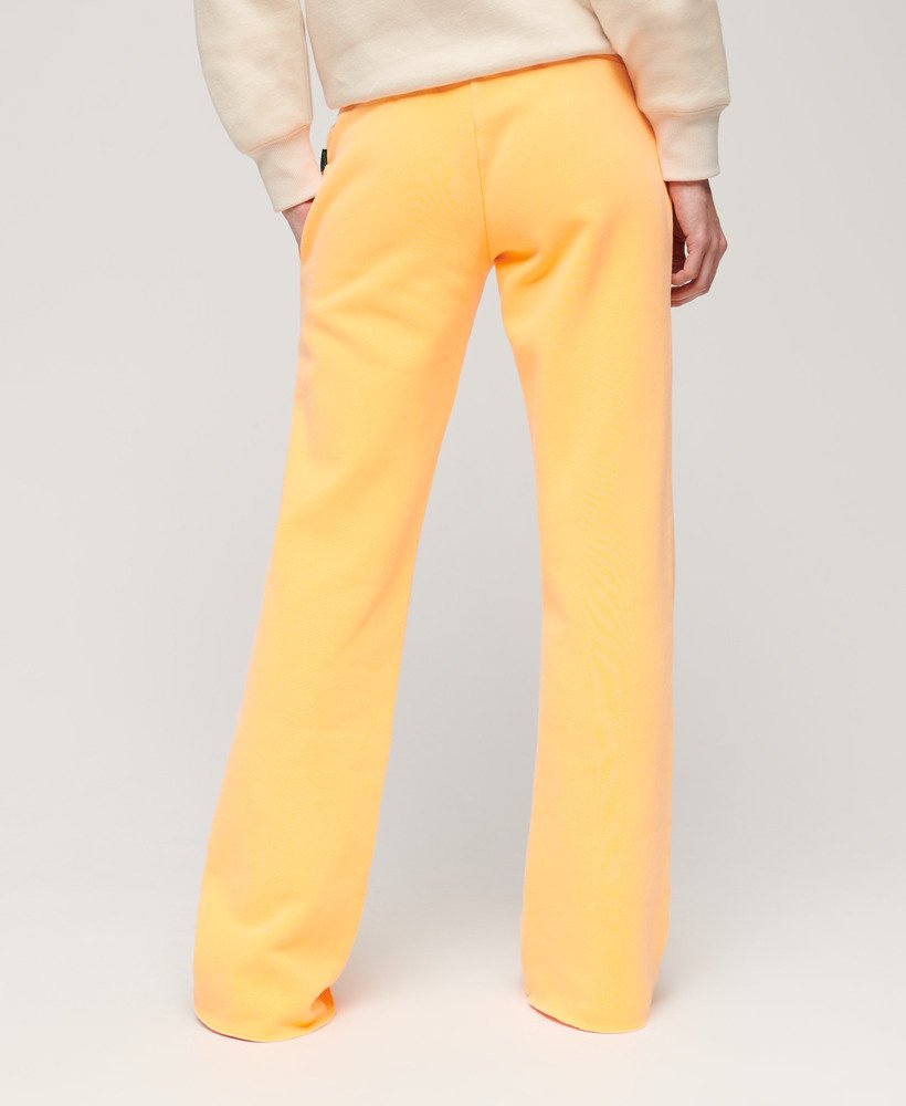 calça jogger flare de cintura baixa com logo vintage em neon na cor laranja vibrante.