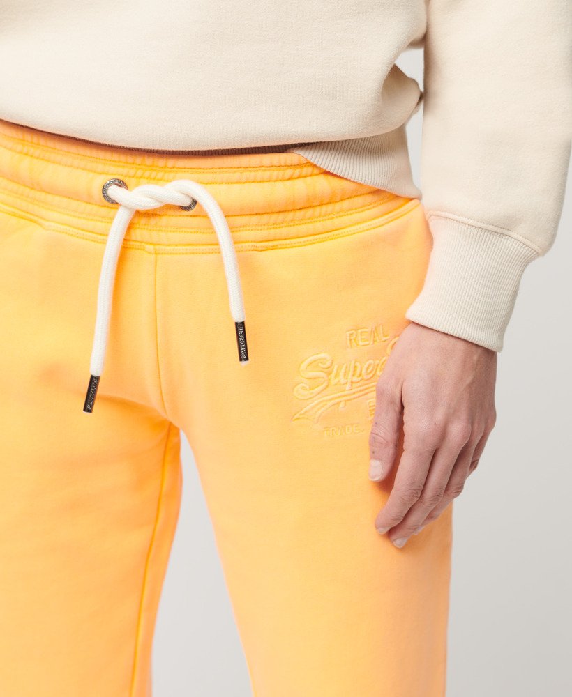 calça jogger flare de cintura baixa com logo vintage em neon na cor laranja vibrante.