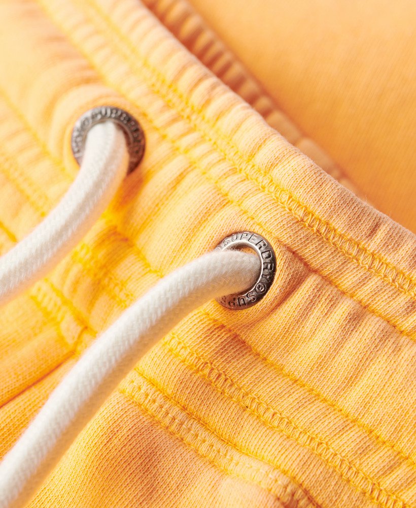 calça jogger flare de cintura baixa com logo vintage em neon na cor laranja vibrante.
