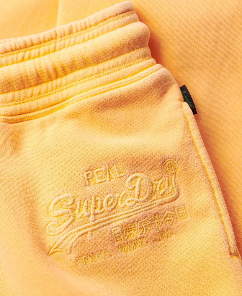 calça jogger flare de cintura baixa com logo vintage em neon na cor laranja vibrante.