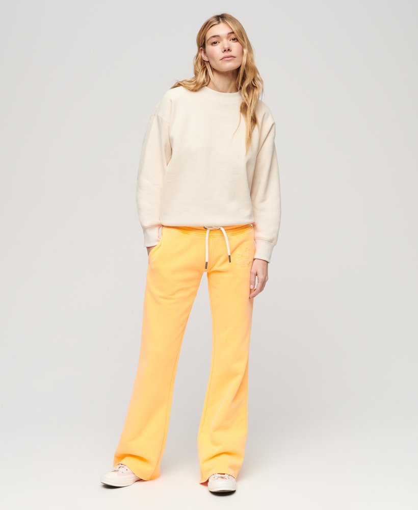 calça jogger flare de cintura baixa com logo vintage em neon na cor laranja vibrante.