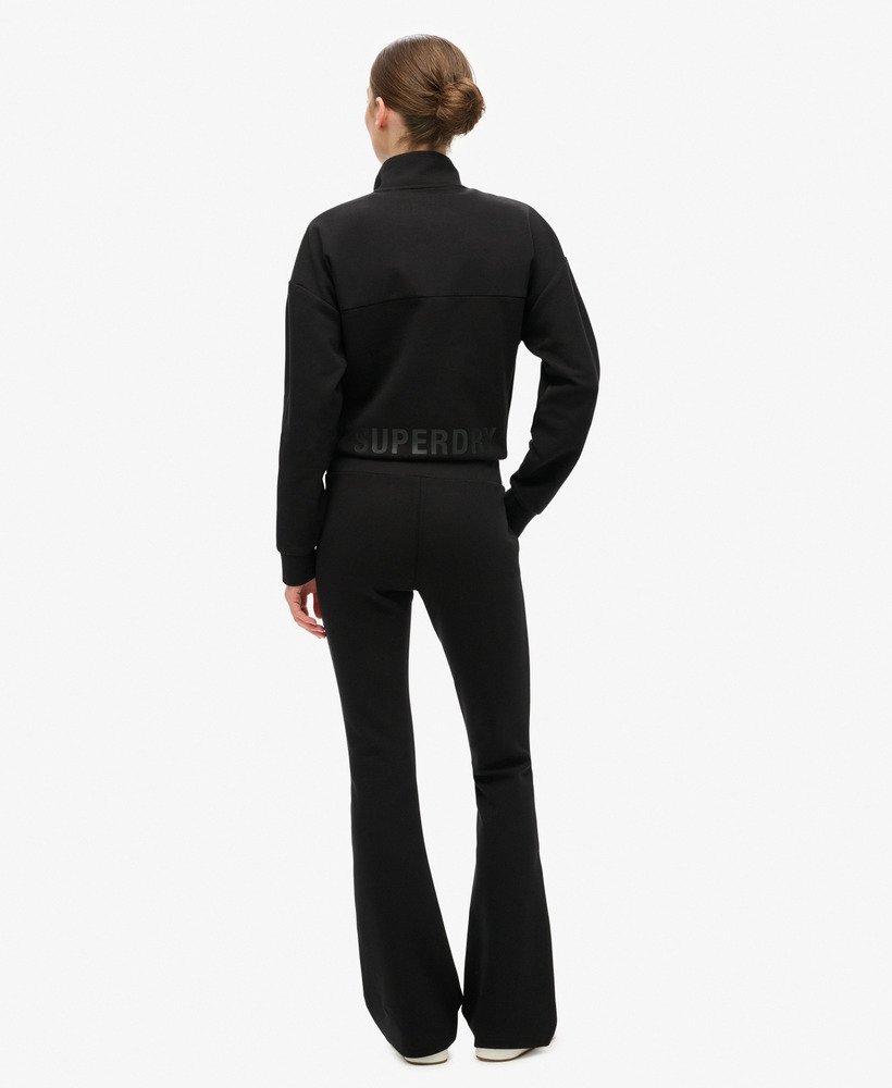 calça de moletom sport tech de cintura baixa e boca larga na cor preta.