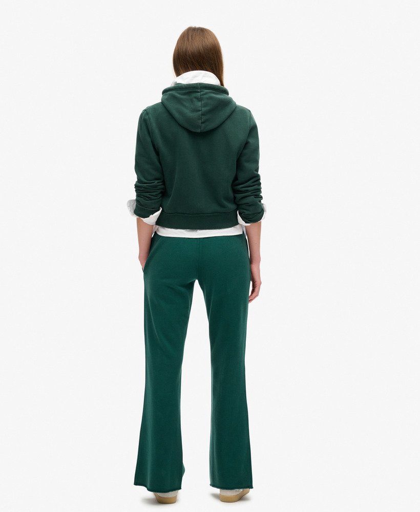 calça de moletom athletic essentials de cintura baixa e boca larga na cor verde pinho escuro.