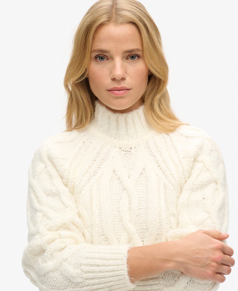 suéter de gola alta em tricô trançado na cor branco off-white.