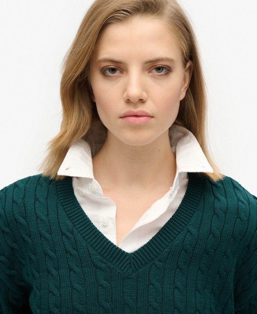 suéter oversized com decote em v e tranças na cor verde pinho escuro.