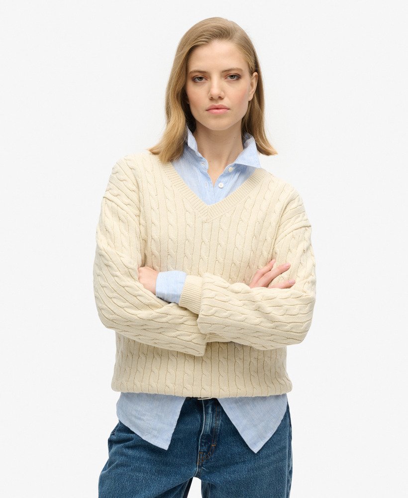 suéter oversized com decote em v e tranças na cor bege aveia.