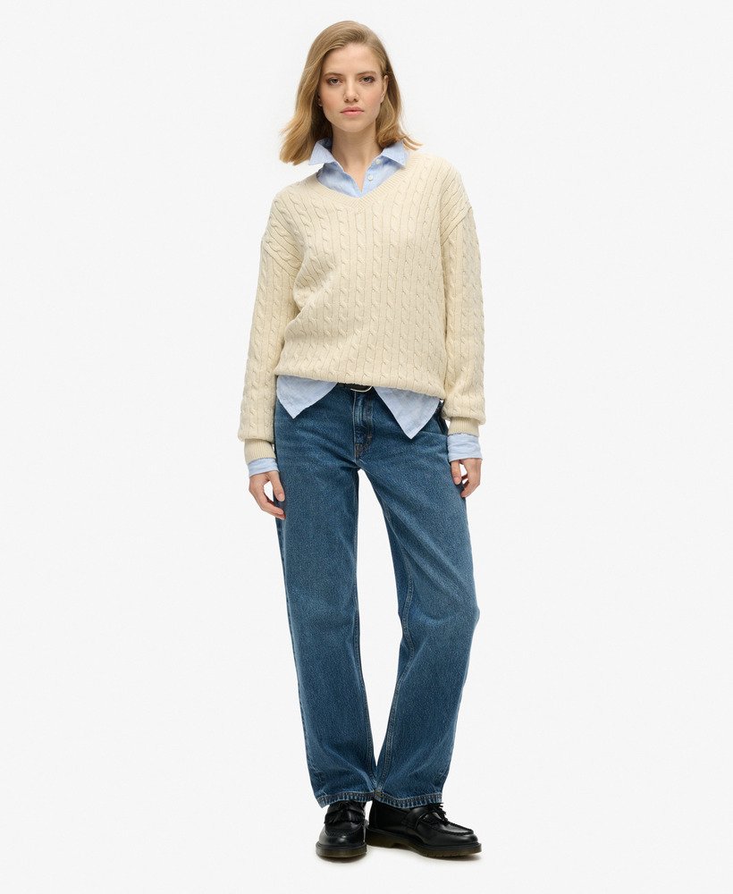 suéter oversized com decote em v e tranças na cor bege aveia.