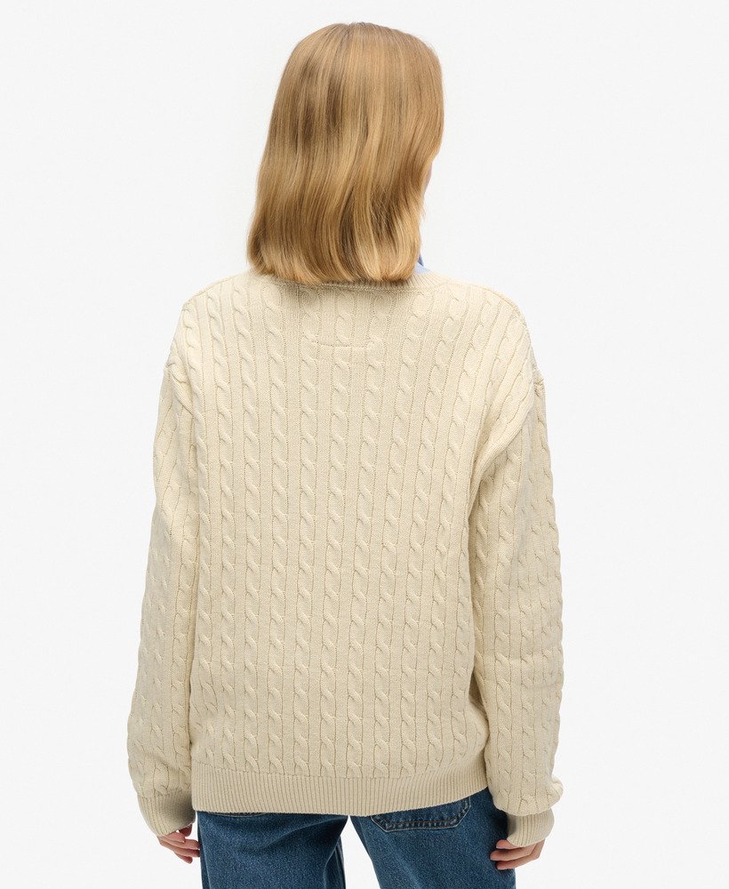 suéter oversized com decote em v e tranças na cor bege aveia.