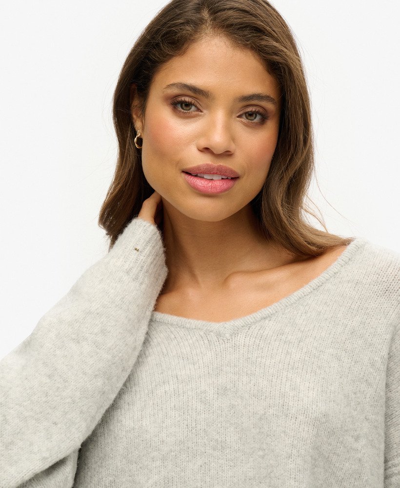 suéter oversized com decote em v na cor cinza claro torcido.