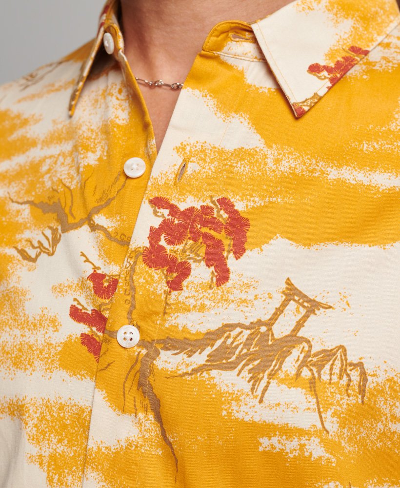 camisa havaiana de manga curta com estampa de nuvens amarelas.