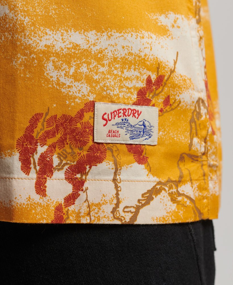 camisa havaiana de manga curta com estampa de nuvens amarelas.