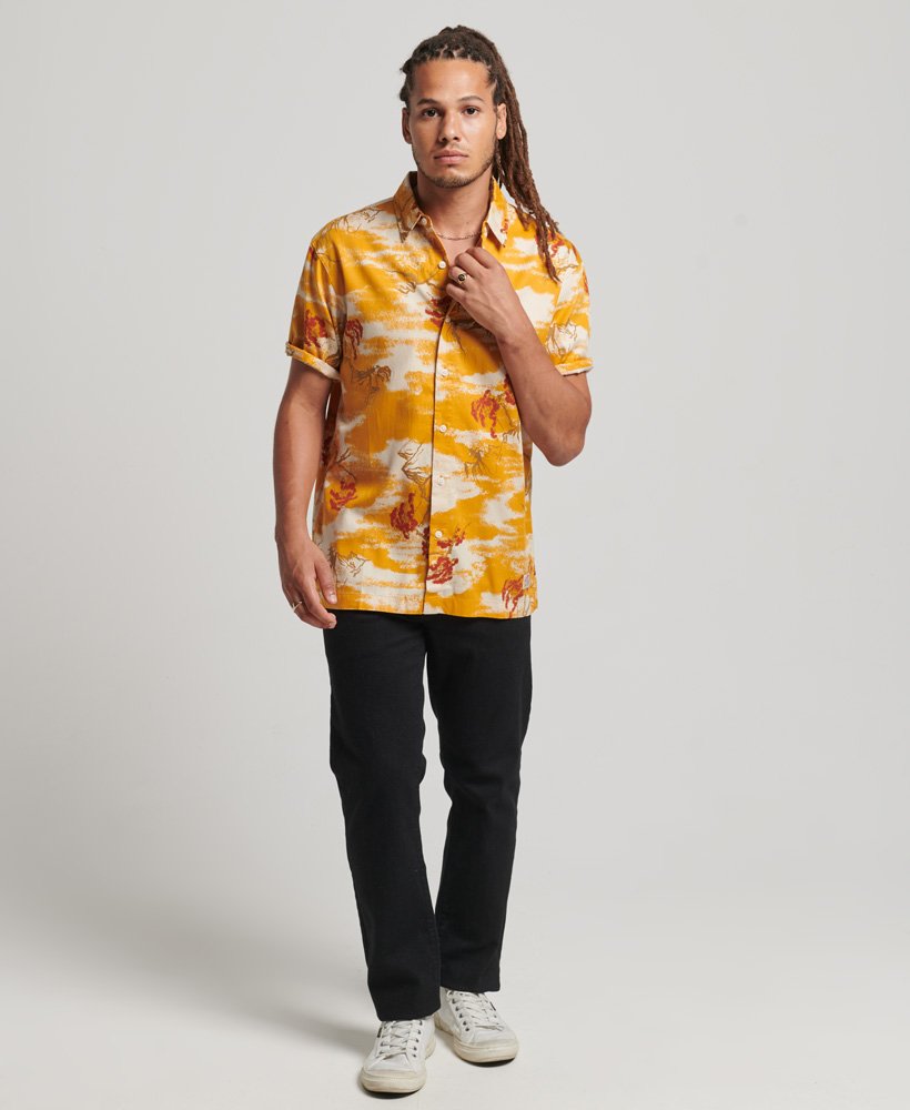 camisa havaiana de manga curta com estampa de nuvens amarelas.