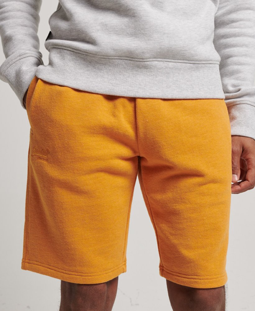 shorts de malha vintage com logo bordado em tom dourado mesclado estilo brechó.