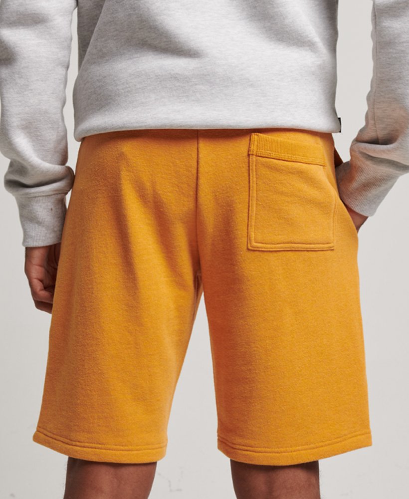 shorts de malha vintage com logo bordado em tom dourado mesclado estilo brechó.