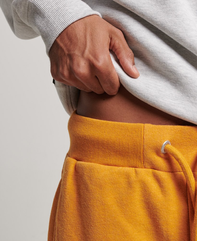 shorts de malha vintage com logo bordado em tom dourado mesclado estilo brechó.
