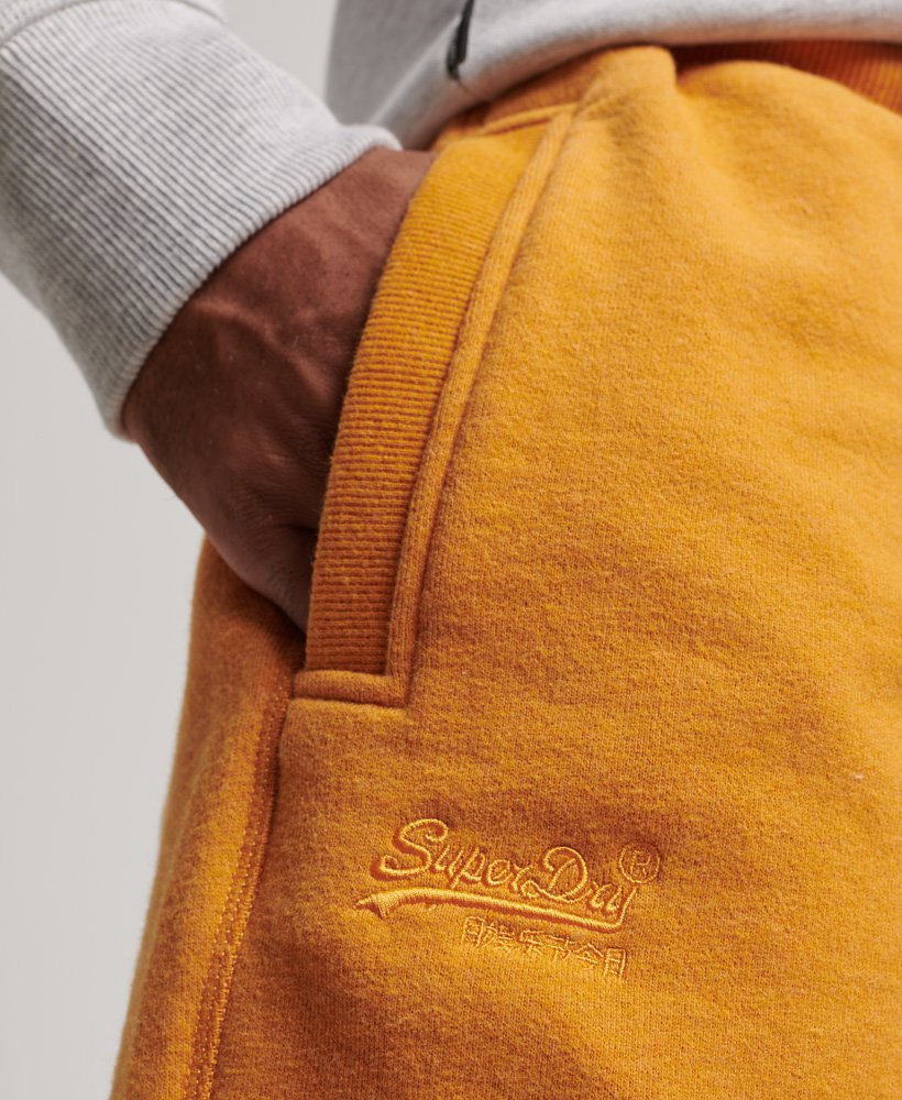 shorts de malha vintage com logo bordado em tom dourado mesclado estilo brechó.