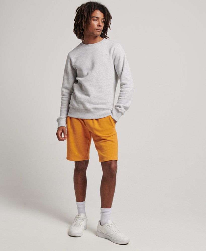 shorts de malha vintage com logo bordado em tom dourado mesclado estilo brechó.