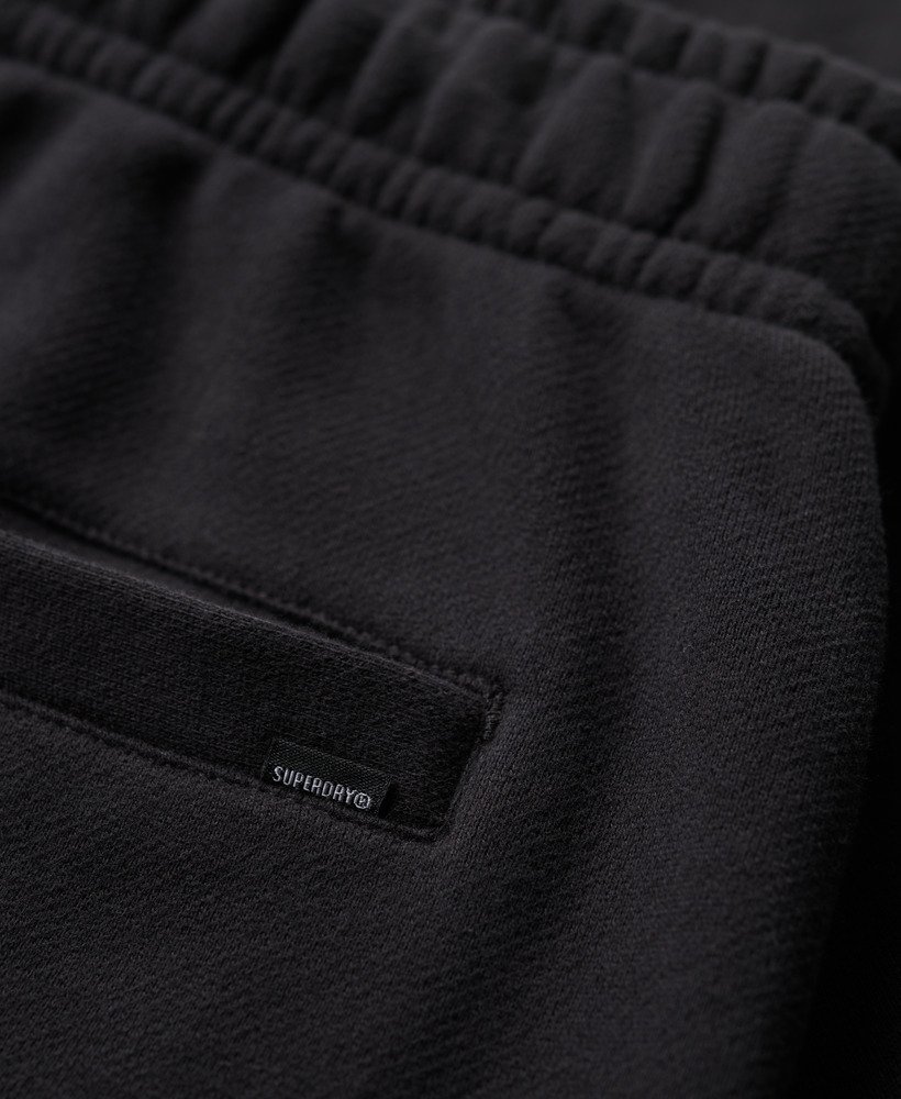 calções folgados com relevo da sportswear na cor preta.
