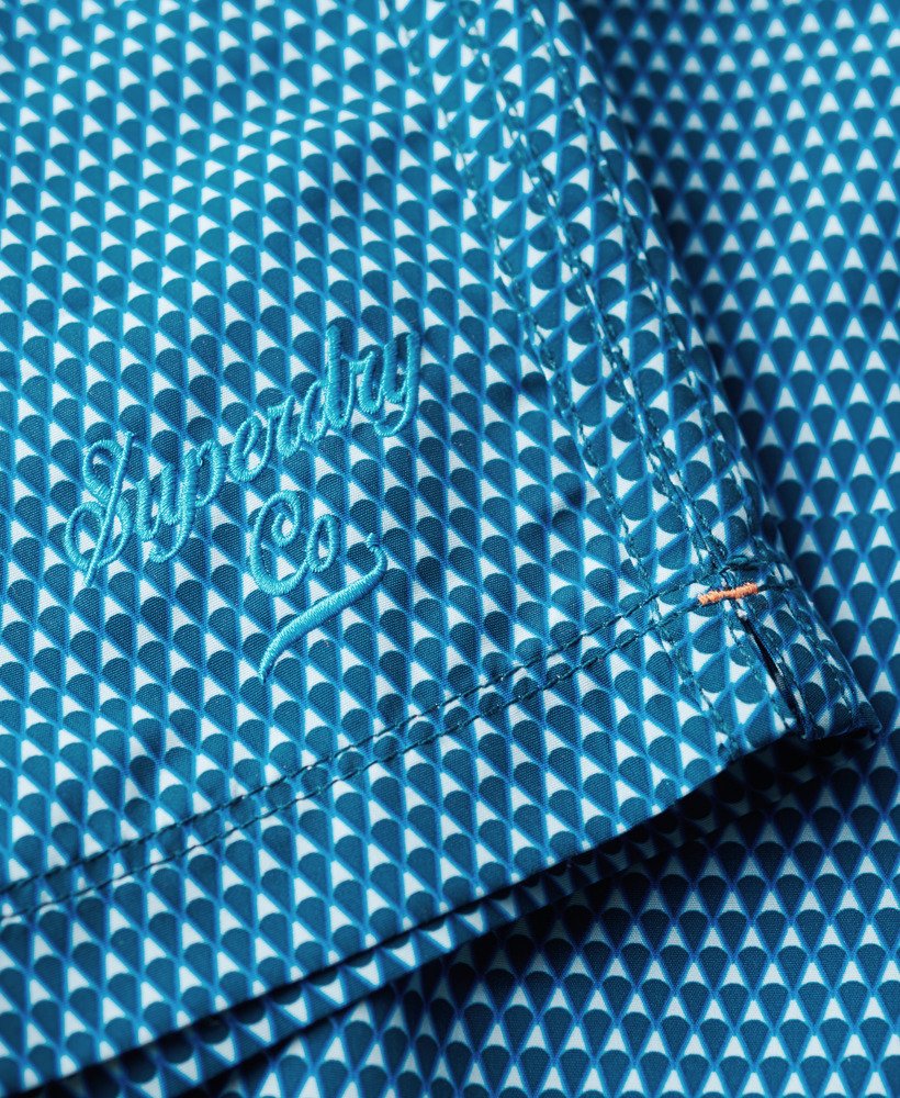 calção de banho reciclado estampado com padrão geométrico azul medindo 38 cm 15 polegadas.