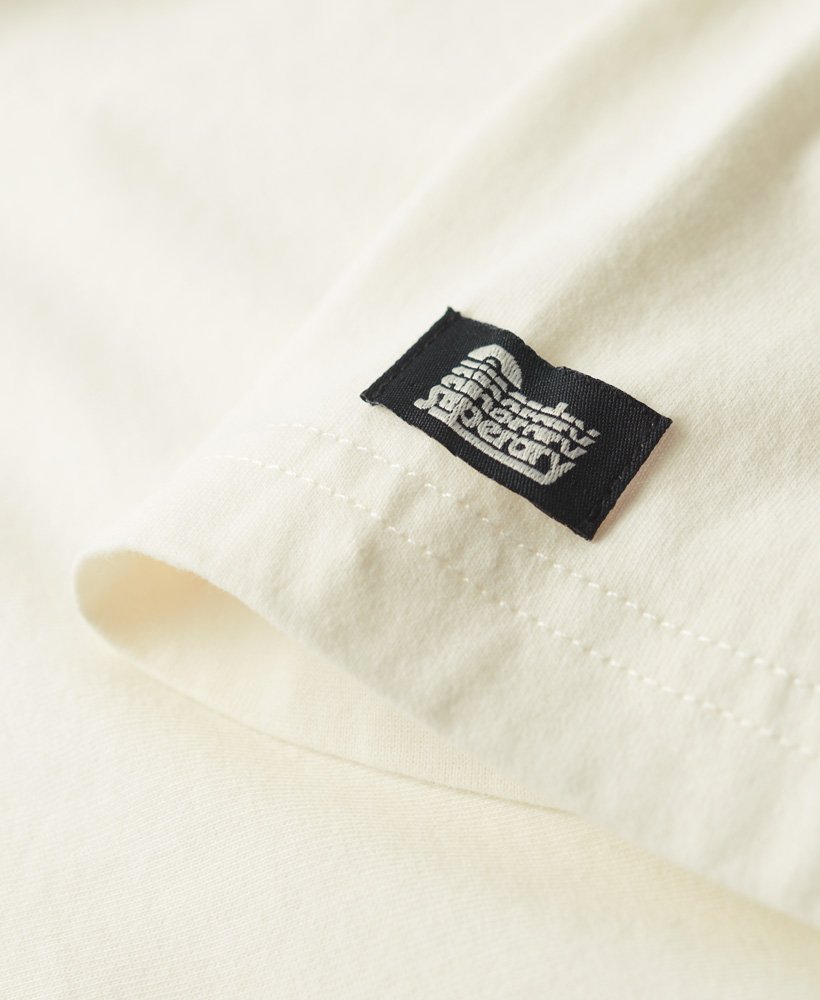 camiseta com estampa frontal de escrita cursiva estilo tatuagem na cor off white.