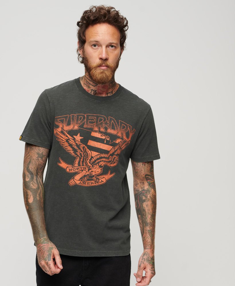 camiseta gráfica lo-fi dos anos 70 com estampa de banda em tecido preto lavado com textura irregular.