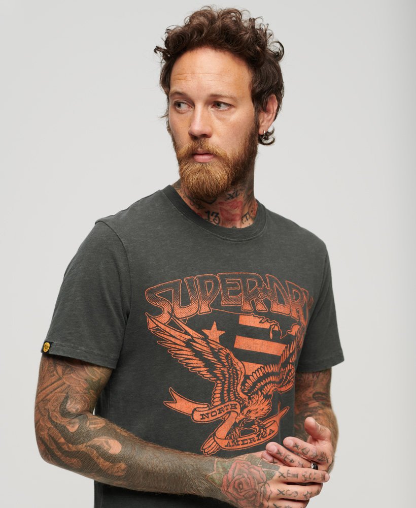 camiseta gráfica lo-fi dos anos 70 com estampa de banda em tecido preto lavado com textura irregular.