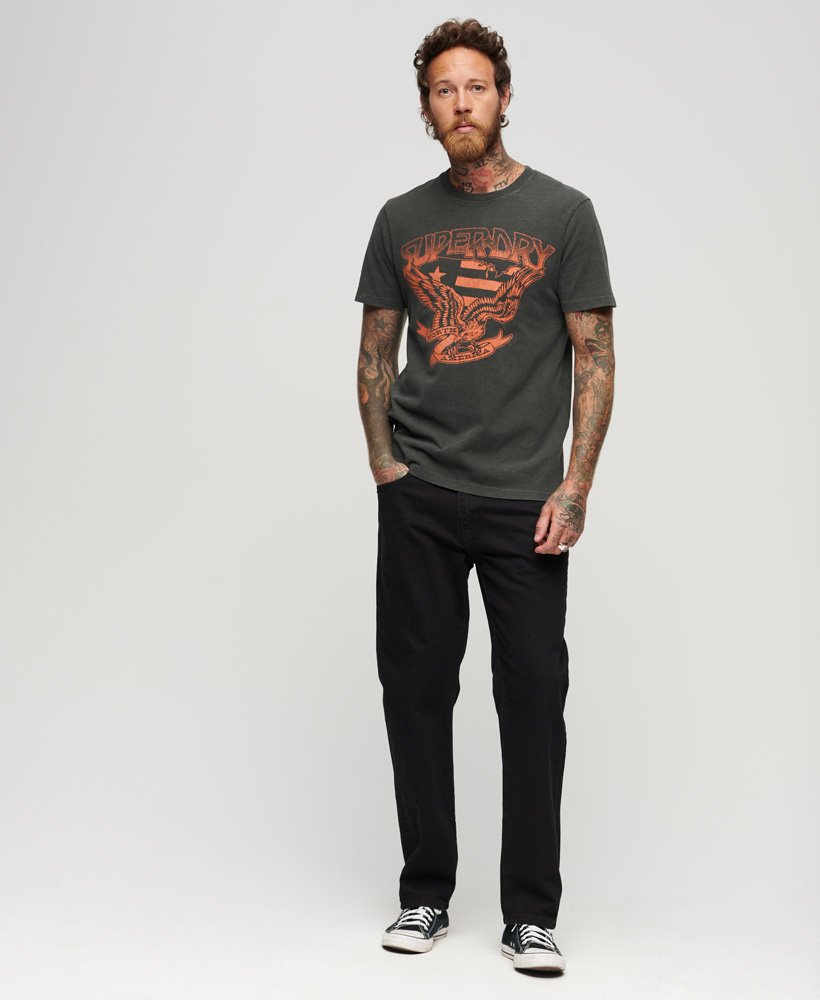 camiseta gráfica lo-fi dos anos 70 com estampa de banda em tecido preto lavado com textura irregular.