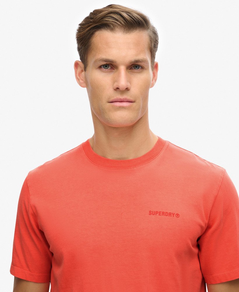camiseta folgada com logo tingido em tom coral vibrante.