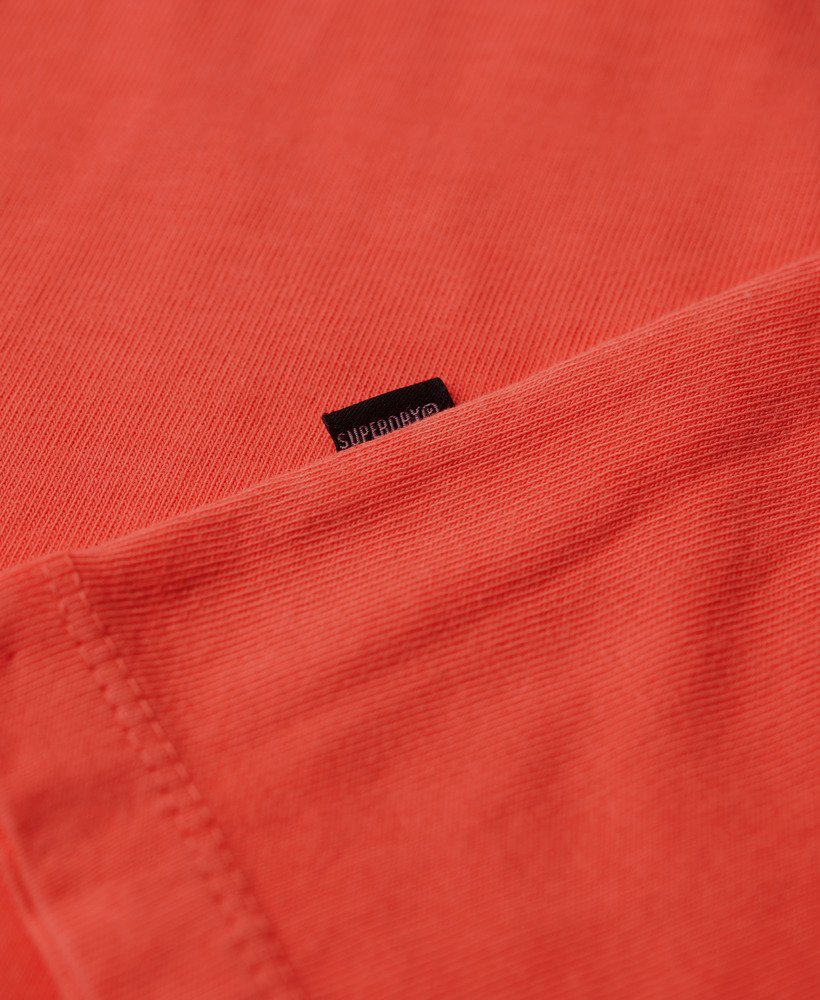 camiseta folgada com logo tingido em tom coral vibrante.