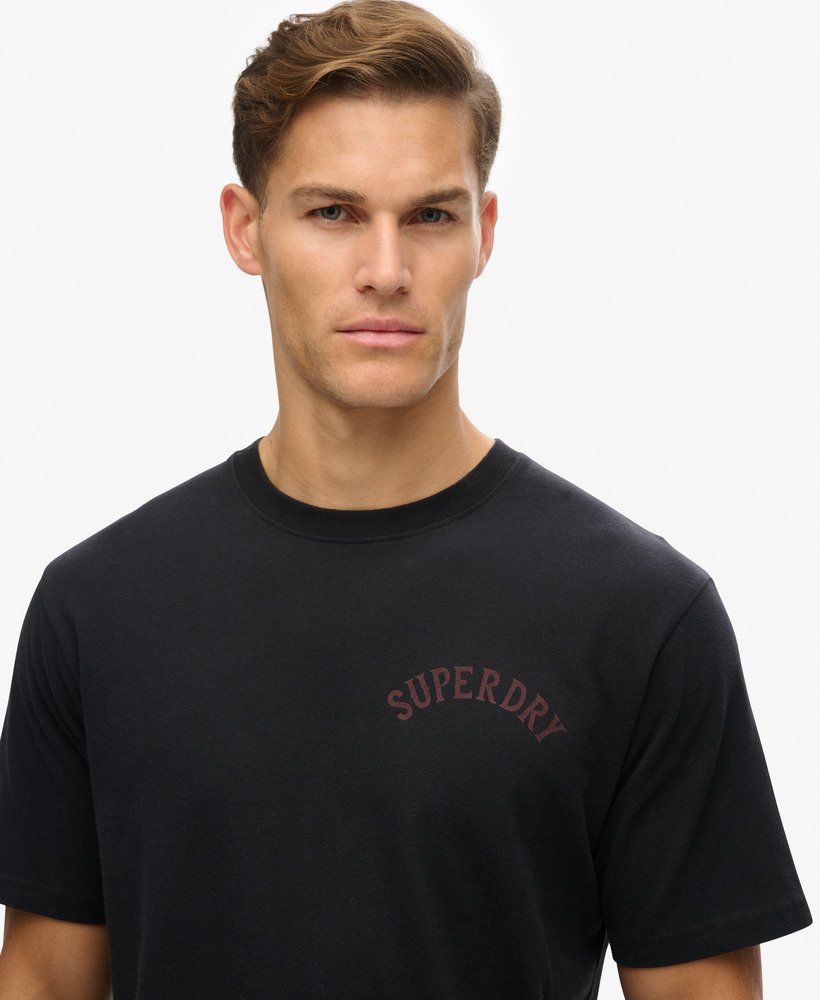 camiseta preta com estampa de tatuagem e modelagem folgada.