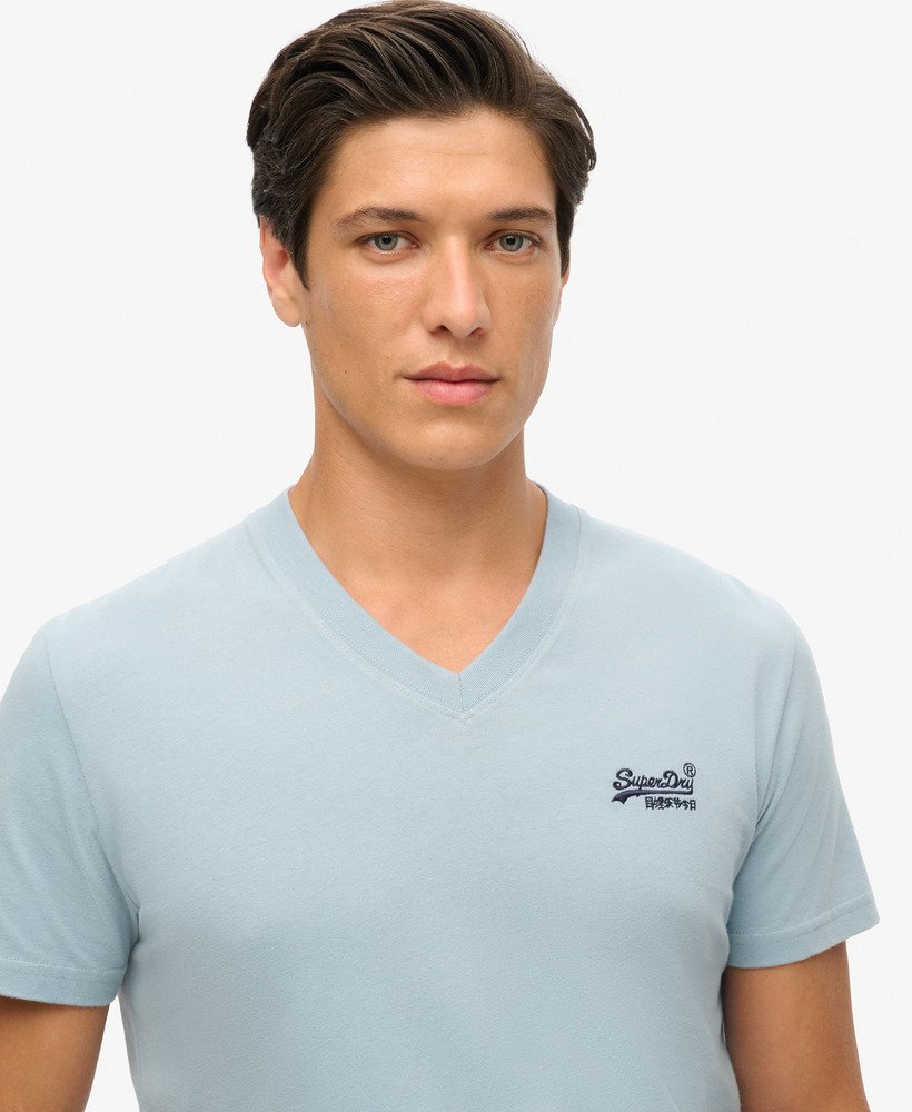 camiseta de algodão orgânico com decote em v e logo essencial na cor azul china.