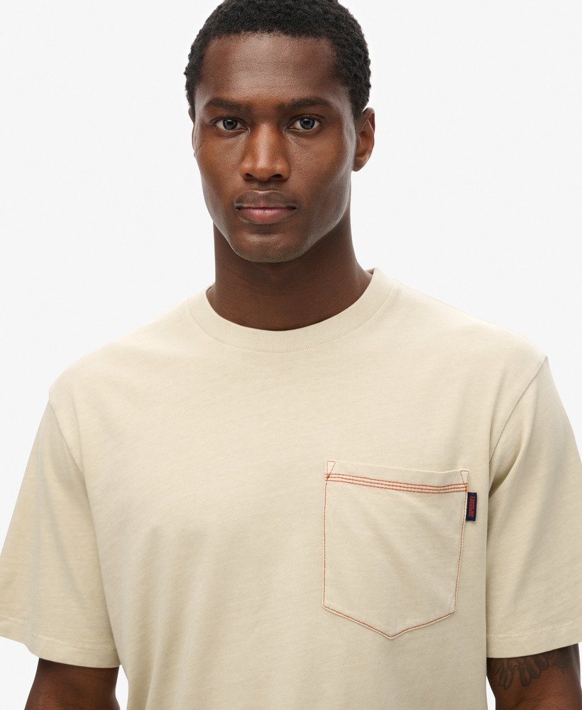 camiseta com bolso e costura contrastante na cor bege pelicano lavado.
