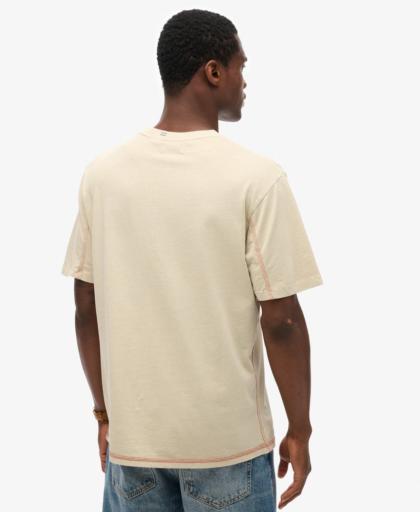 camiseta com bolso e costura contrastante na cor bege pelicano lavado.