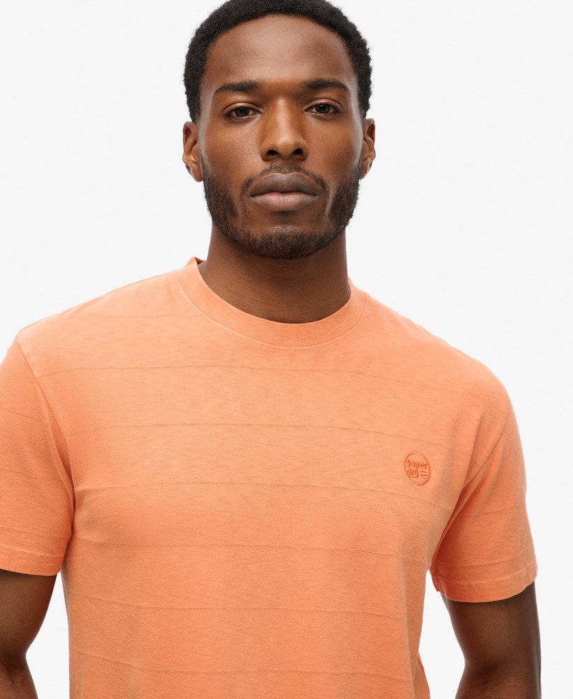 camiseta de algodão orgânico com textura vintage na cor laranja ferrugem defumada.
