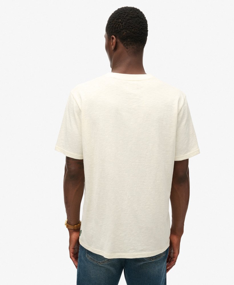 camiseta folgada com estampa de viagem em neon na cor off-white com textura irregular.