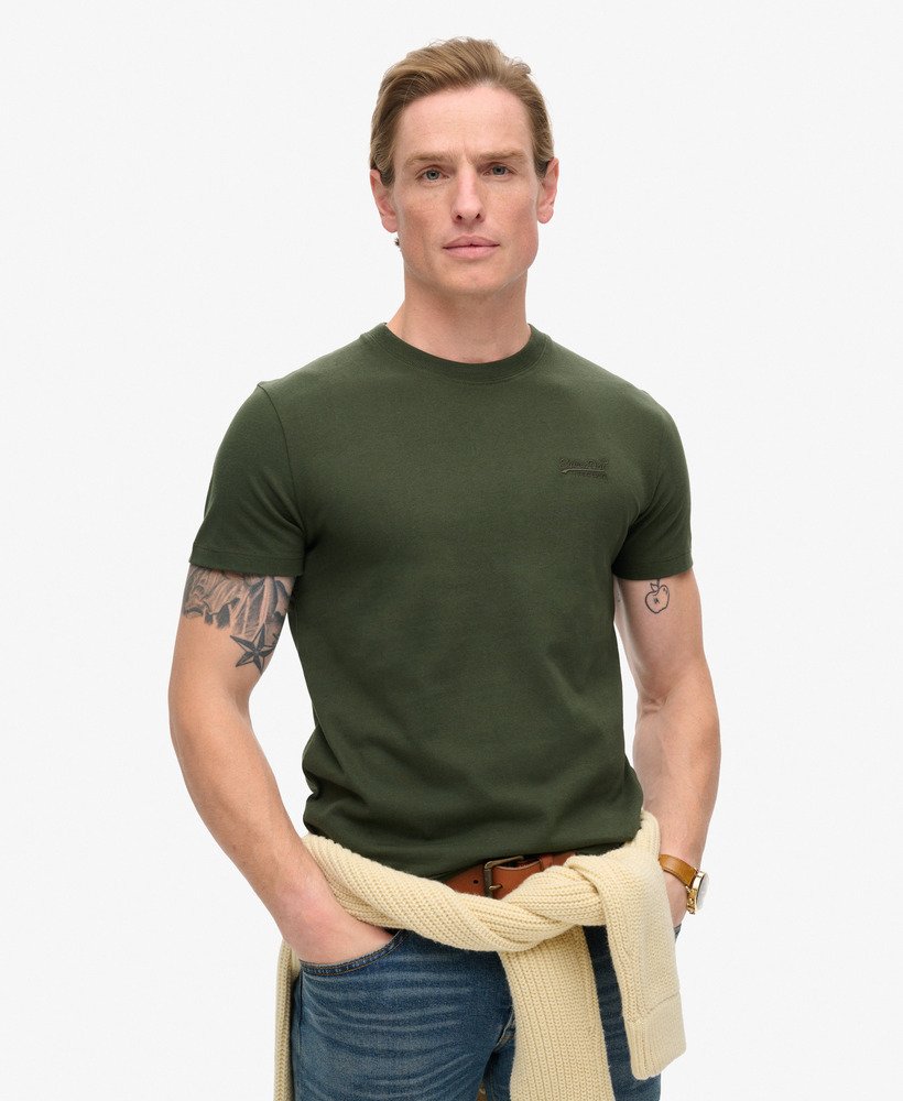 camiseta essential logo em algodão orgânico dentro de uma bolsa de viagem verde.