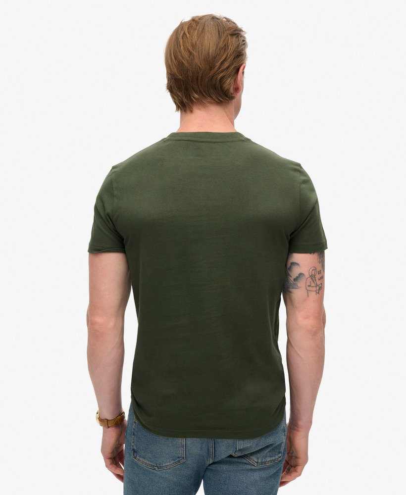camiseta essential logo em algodão orgânico dentro de uma bolsa de viagem verde.