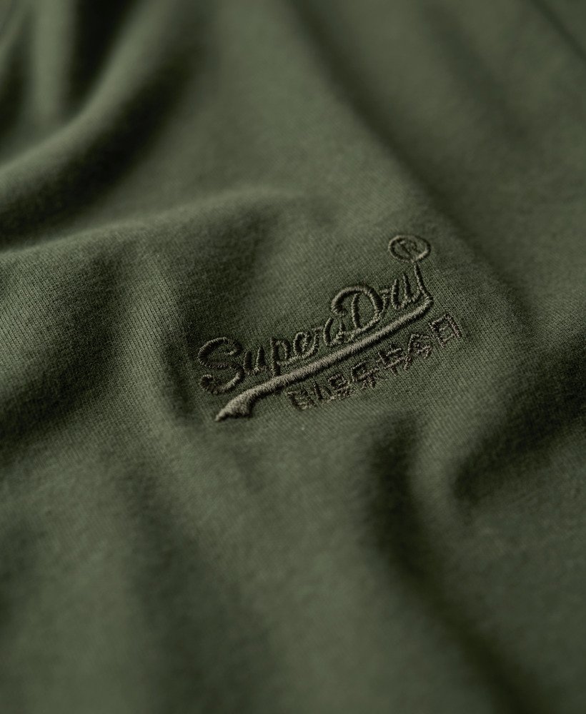 camiseta essential logo em algodão orgânico dentro de uma bolsa de viagem verde.