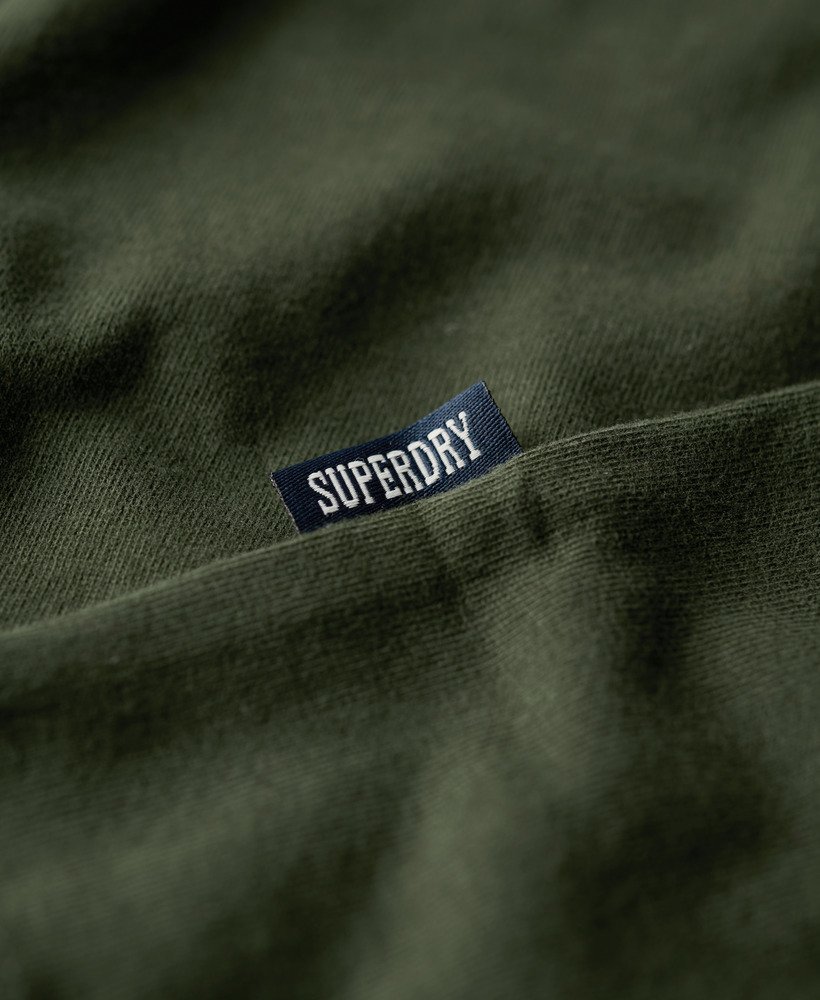 camiseta essential logo em algodão orgânico dentro de uma bolsa de viagem verde.