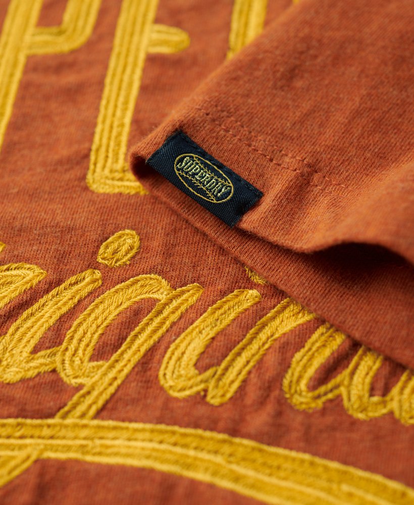 camiseta com estampa esportiva em estilo script na cor laranja ferrugem mesclado.