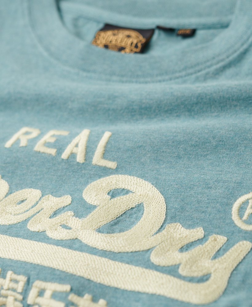 camiseta vintage com logo bordado na cor azul mesclado.